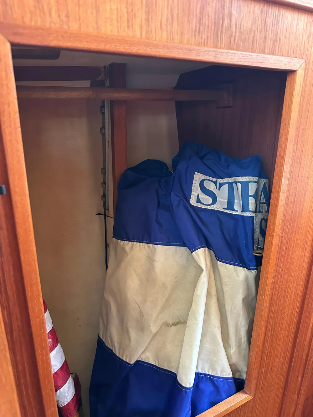 Wooden cabinet on 1985 Sabre 34 MKI sailboat with stored blue and white sail.
