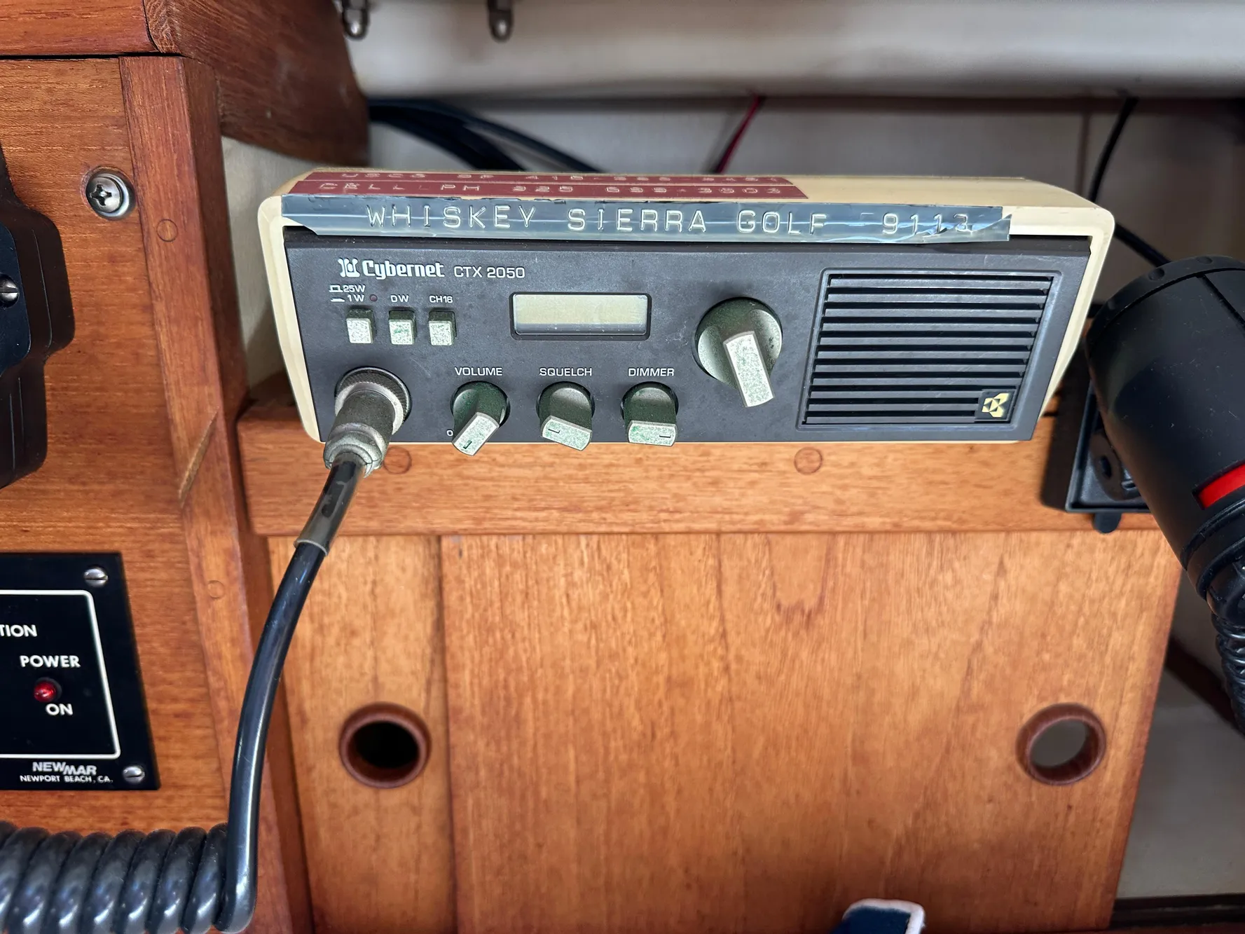 Vintage Cybernet CTX 2050 radio on 1985 Sabre 34 MKI sailboat, wooden panel background.