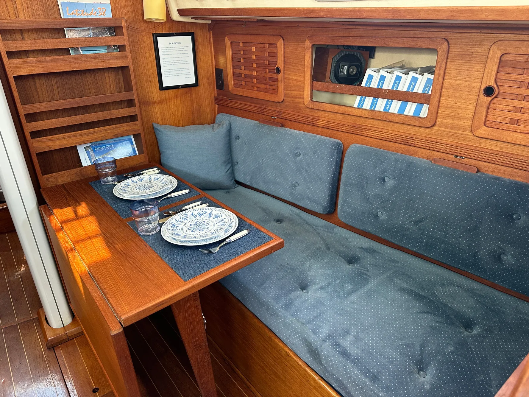Cozy interior of 1985 Sabre 34 MKI sailboat with dining setup and blue cushions.