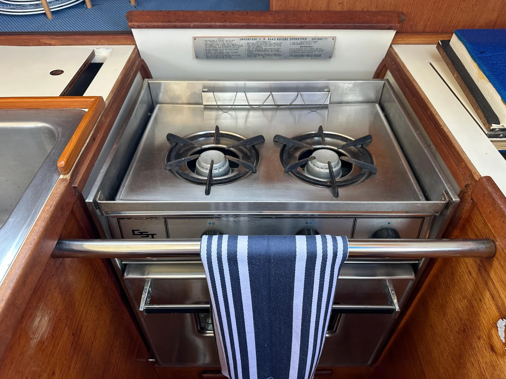 1985 Sabre 34 MKI yacht kitchen with stainless steel stove and striped towel.