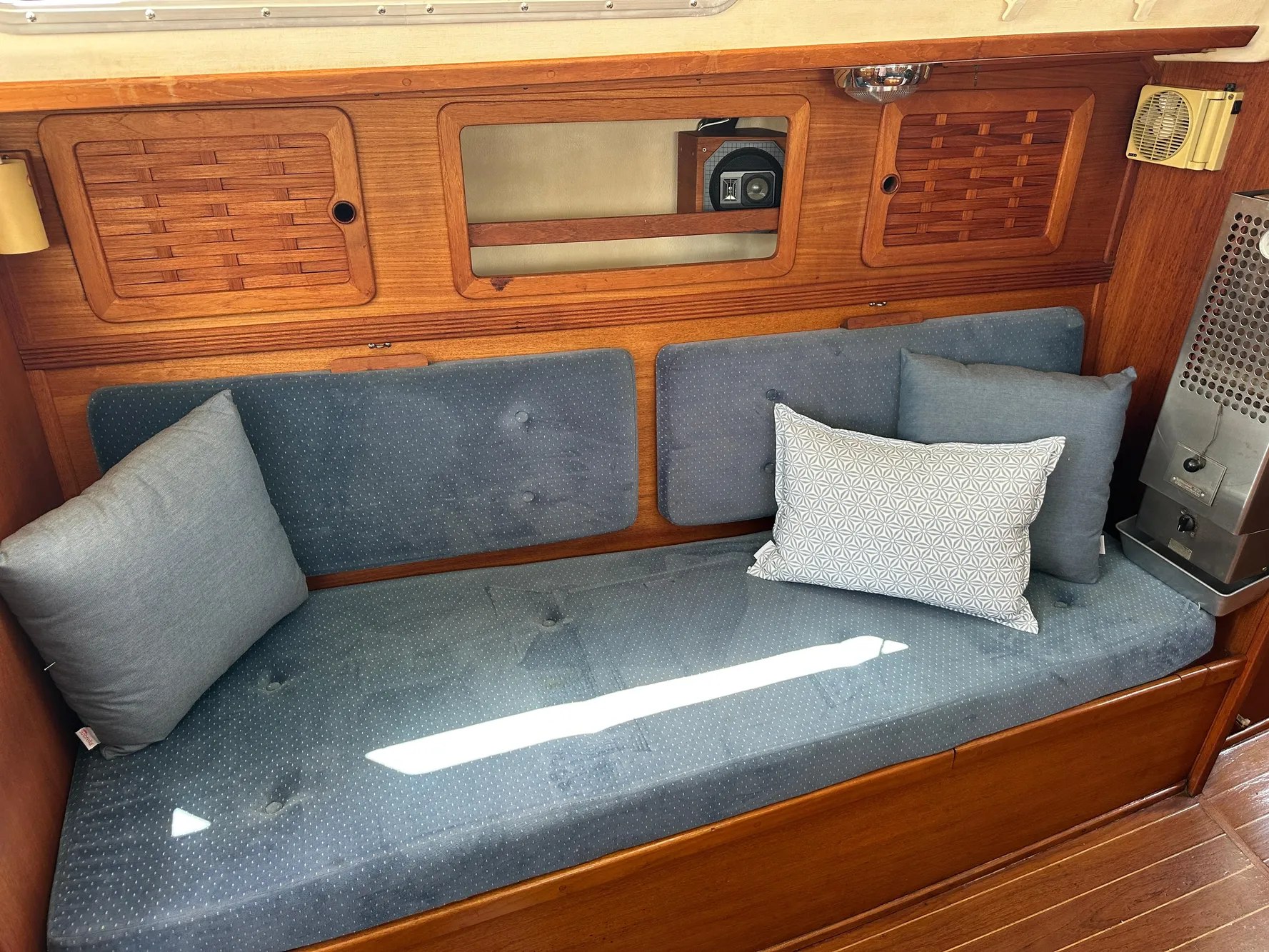 Interior of 1985 Sabre 34 MKI sailboat with blue cushioned seating and wooden paneling.