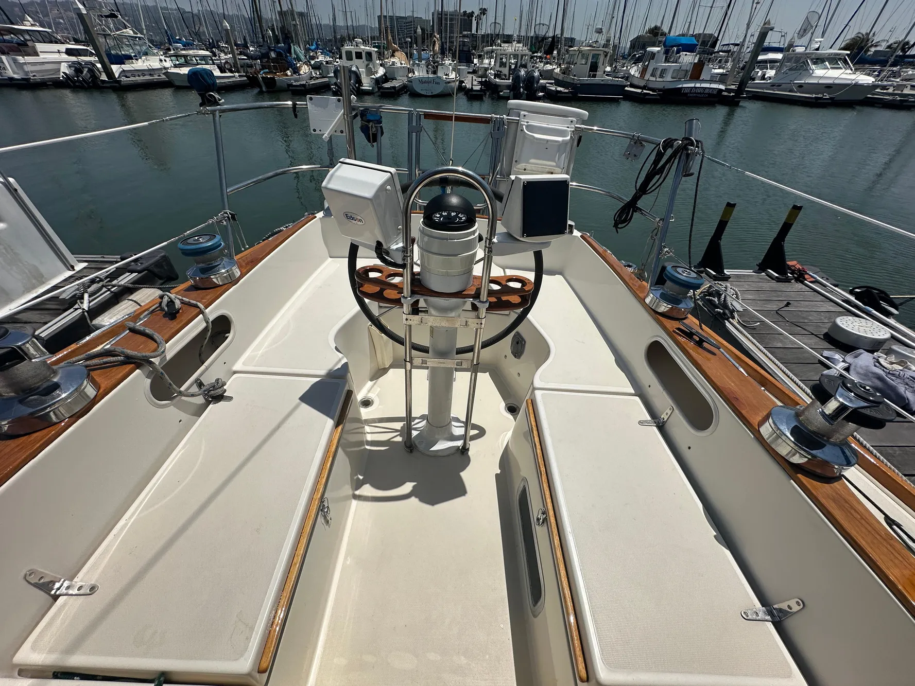 1985 Sabre 34 MKI sailboat cockpit with steering wheel, docked in marina.