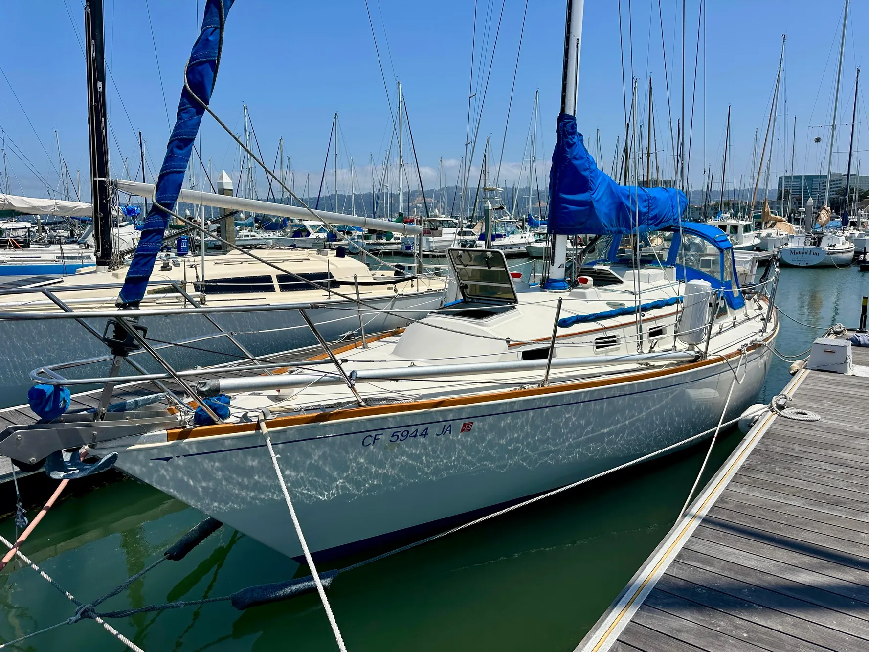 1985 Sabre 34 MKI sailboat docked in a marina under clear blue skies.