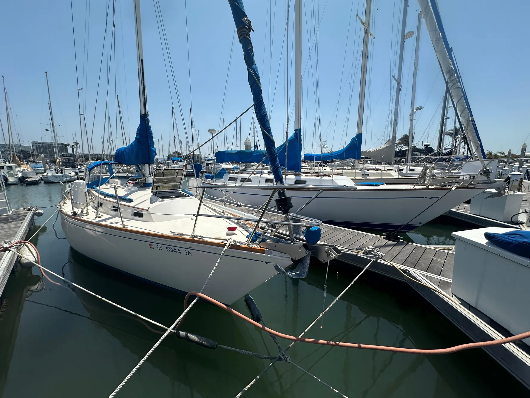 1985 Sabre 34 MKI sailboat docked in marina, surrounded by other boats.