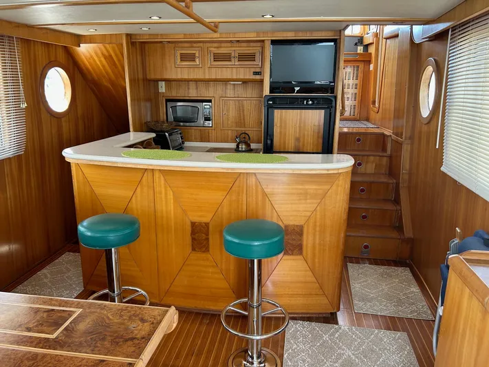 Duet Yacht Photos Pics Interior of 1999 Selene 43 yacht with wooden bar, stools, and kitchen appliances.
