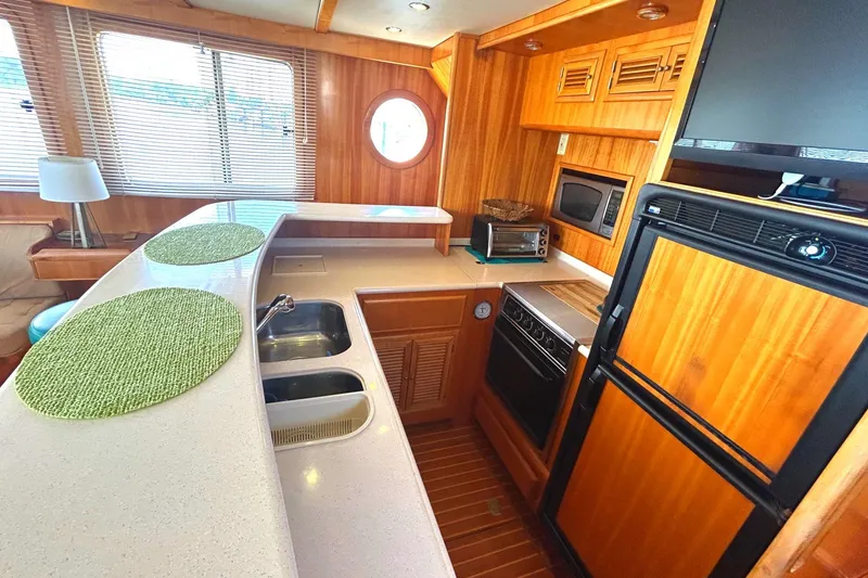 Duet Yacht Photos Pics Luxurious Selene 43 yacht kitchen interior, featuring wood cabinetry, modern appliances, and ample counter space.