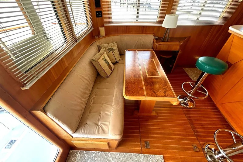 Duet Yacht Photos Pics Luxurious Selene 43 yacht interior with wooden table, cushioned seating, and bar stools, 1999 model.
