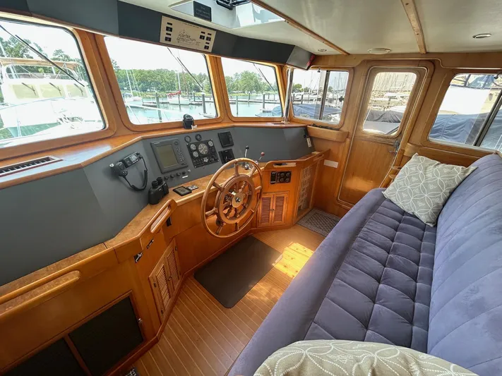 Duet Yacht Photos Pics Interior of 1999 Selene 43 yacht with wooden helm, plush seating, and navigation equipment.