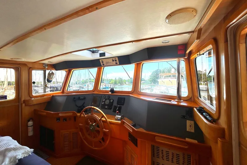 Duet Yacht Photos Pics Interior view of 1999 Selene 43 boat cockpit with wooden steering wheel and navigation controls.