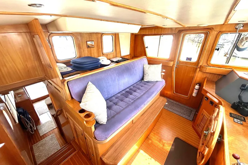 Duet Yacht Photos Pics Cozy interior of 1999 Selene 43 yacht with wooden finish and blue seating.