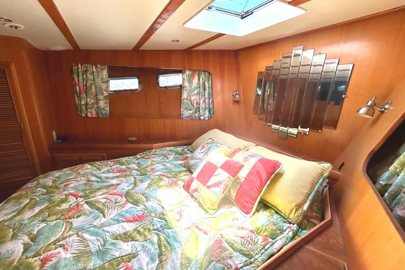 Duet Yacht Photos Pics Cozy bedroom in 1999 Selene 43 yacht with floral bedding and wooden interior.