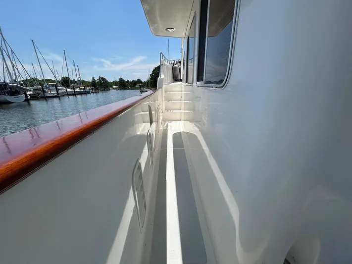 Duet Yacht Photos Pics Side deck of 1999 Selene 43 yacht with polished wood railing, docked at marina.