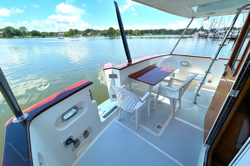 Duet Yacht Photos Pics 1999 Selene 43 yacht deck with table, chairs, and scenic waterfront view.