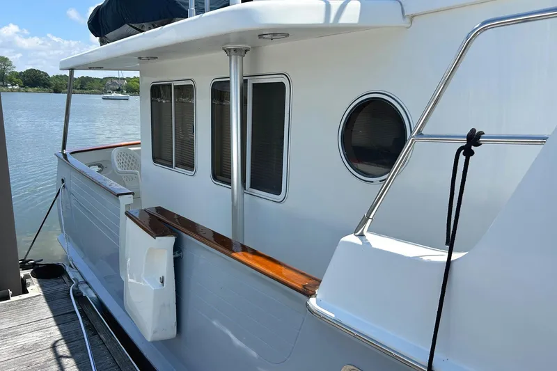Duet Yacht Photos Pics Side view of a 1999 Selene 43 yacht docked by a calm lake.