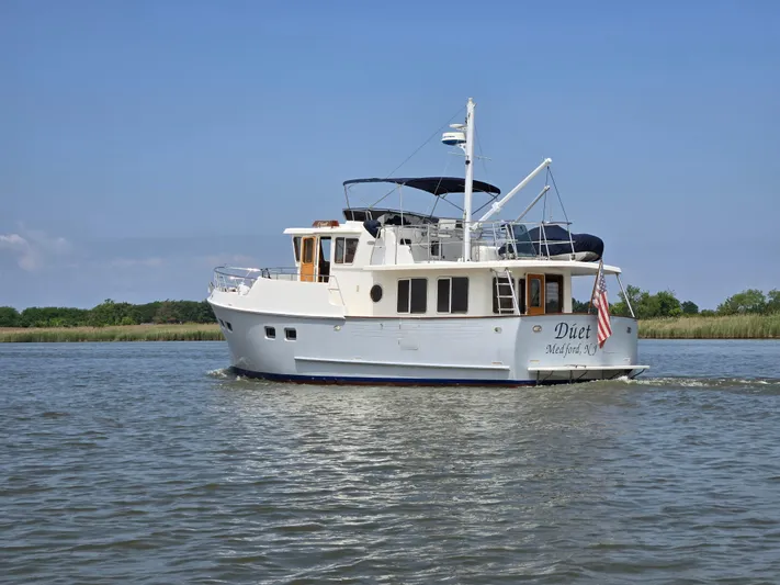 Duet Yacht Photos Pics Selene 43 yacht cruising on a calm river, 1999 model, with clear skies.