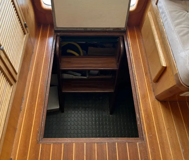 Duet Yacht Photos Pics Wooden hatch with steps leading to storage in a 1999 Selene 43 boat interior.