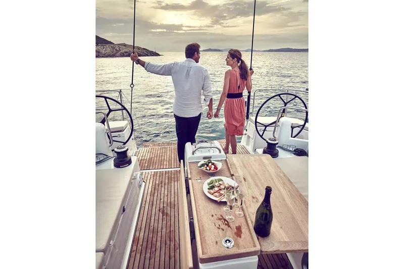  Yacht Photos Pics Manufacturer Provided Image: Couple enjoying sunset on Jeanneau Sun Odyssey 490 yacht, 2020 model, with dinner on deck.