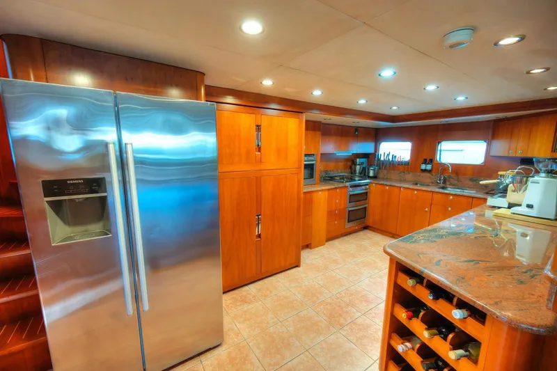 Voyager Yacht Photos Pics Luxurious 2004 Algar Explorer yacht kitchen with wooden cabinetry and modern appliances.