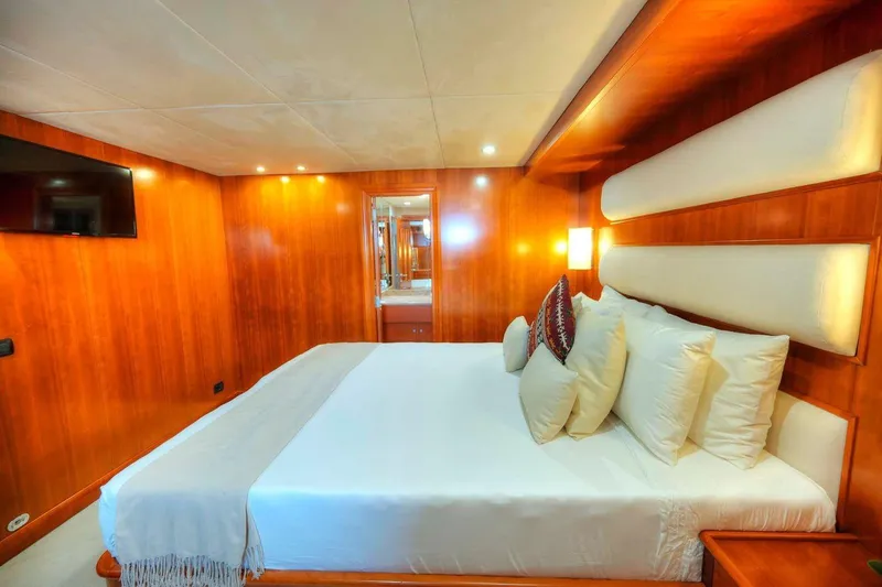Voyager Yacht Photos Pics Luxurious 2004 Algar Explorer yacht bedroom with wood paneling and plush bedding.