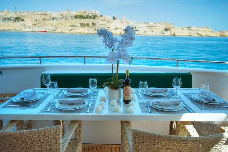 Voyager Yacht Photos Pics Elegant dining setup on 2004 Algar Explorer yacht with scenic waterfront view.