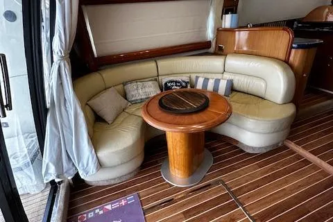 L Altro G Yacht Photos Pics Luxurious 2006 Cranchi Atlantique 48 yacht interior with curved leather seating and wooden table.