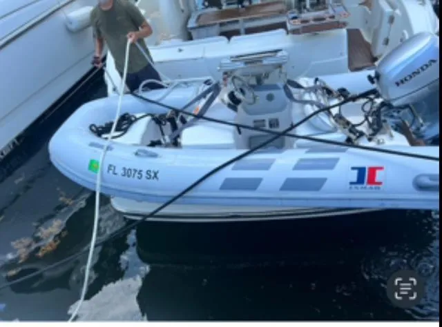 L Altro G Yacht Photos Pics A 2006 Cranchi Atlantique 48 yacht with a small inflatable boat attached.