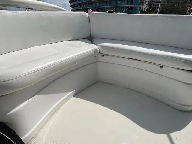 L Altro G Yacht Photos Pics White seating area on 2006 Cranchi Atlantique 48 yacht, with modern design and urban backdrop.