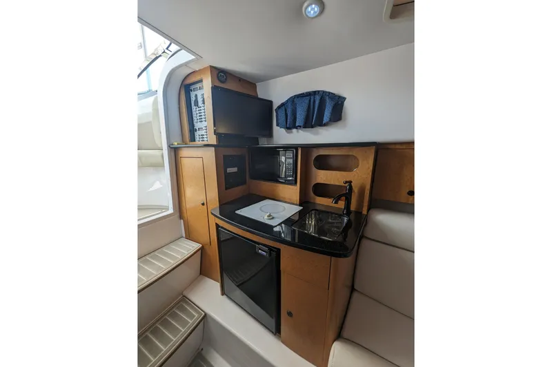 'why Knot' Yacht Photos Pics 2008 Donzi 38 ZSF boat interior with kitchenette, featuring sink, microwave, and TV.