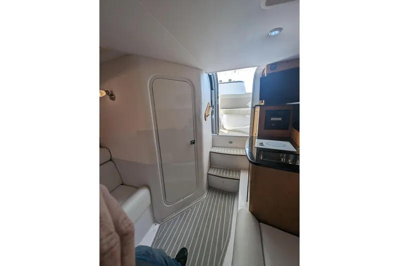 'why Knot' Yacht Photos Pics Interior of 2008 Donzi 38 ZSF boat, featuring seating, steps, and compact kitchenette.