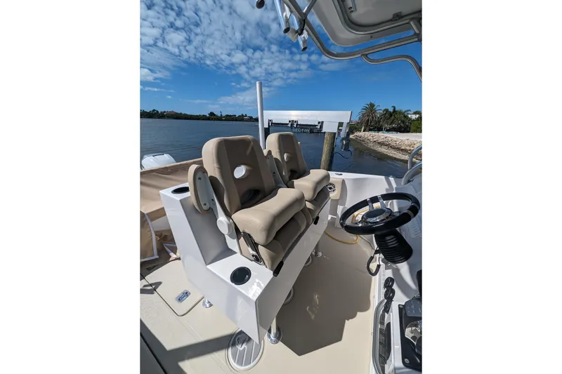 'why Knot' Yacht Photos Pics 2008 Donzi 38 ZSF boat interior with helm and seating, docked by a scenic shoreline.