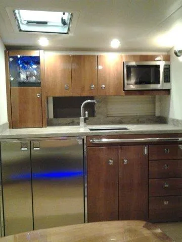  Yacht Photos Pics 2017 Formula 40 Performance Cruiser kitchen with wood cabinets, stainless appliances, and modern fixtures.