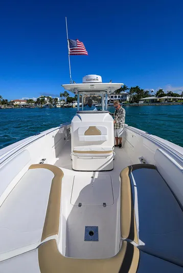  Yacht Photos Pics 2015 Edgewater 320CC boat on water, American flag, clear blue sky.