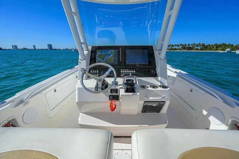  Yacht Photos Pics Edgewater 320CC 2015 boat cockpit with steering wheel and navigation screens on open water.