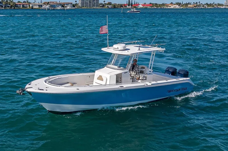  Yacht Photos Pics 2015 Edgewater 320CC boat cruising on blue ocean waters with American flag.