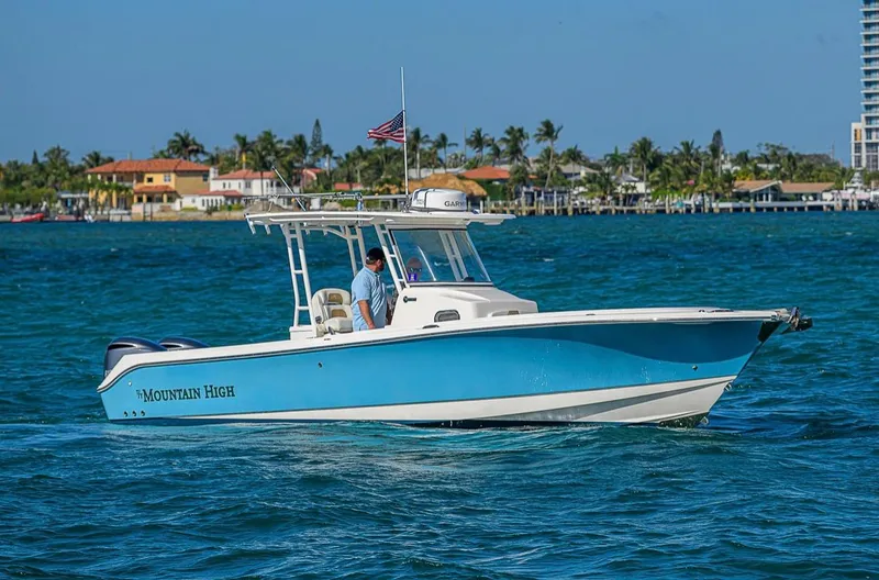  Yacht Photos Pics 2015 Edgewater 320CC boat "Mountain High" cruising on blue waters near coastal homes.