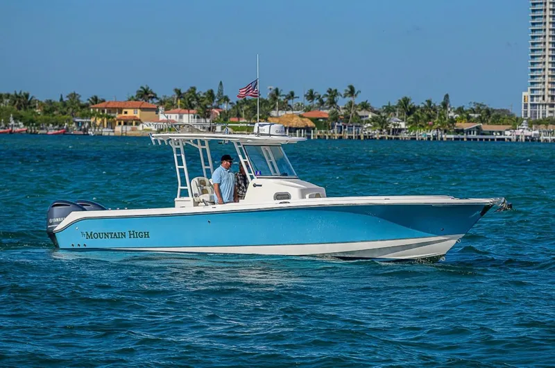  Yacht Photos Pics 2015 Edgewater 320CC boat "Mountain High" cruising on blue waters near a coastal area.