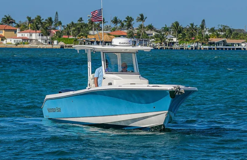  Yacht Photos Pics 2015 Edgewater 320CC boat cruising on blue water near a coastal town.