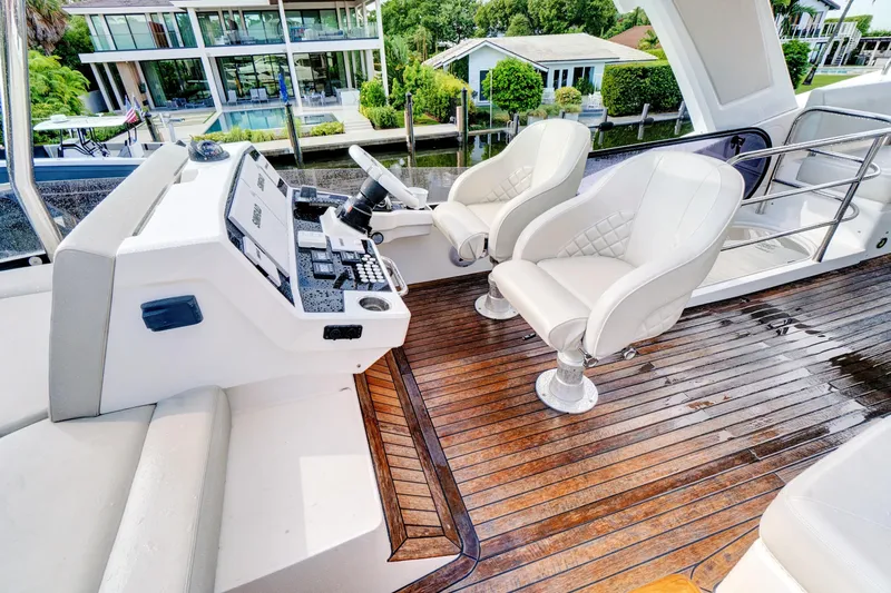 Joie De Vivre Yacht Photos Pics Luxurious 2020 Sunseeker Manhattan 52 yacht helm with elegant seating and polished wood deck.