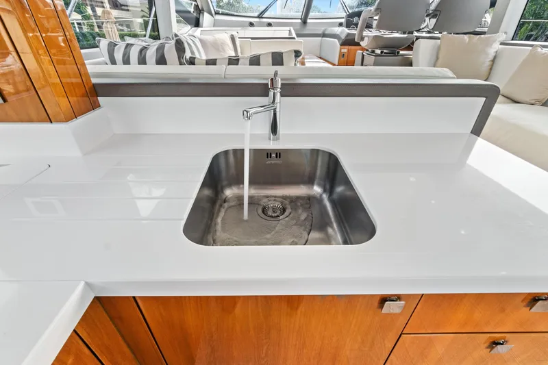 Joie De Vivre Yacht Photos Pics Modern kitchen sink on 2020 Sunseeker Manhattan 52 yacht with sleek design and wooden cabinetry.