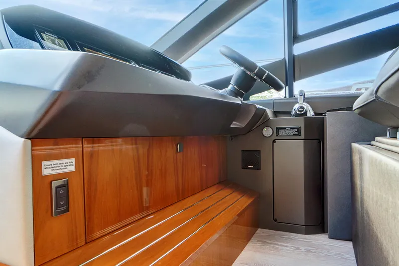 Joie De Vivre Yacht Photos Pics 2020 Sunseeker Manhattan 52 yacht helm with sleek wood finish and modern controls.