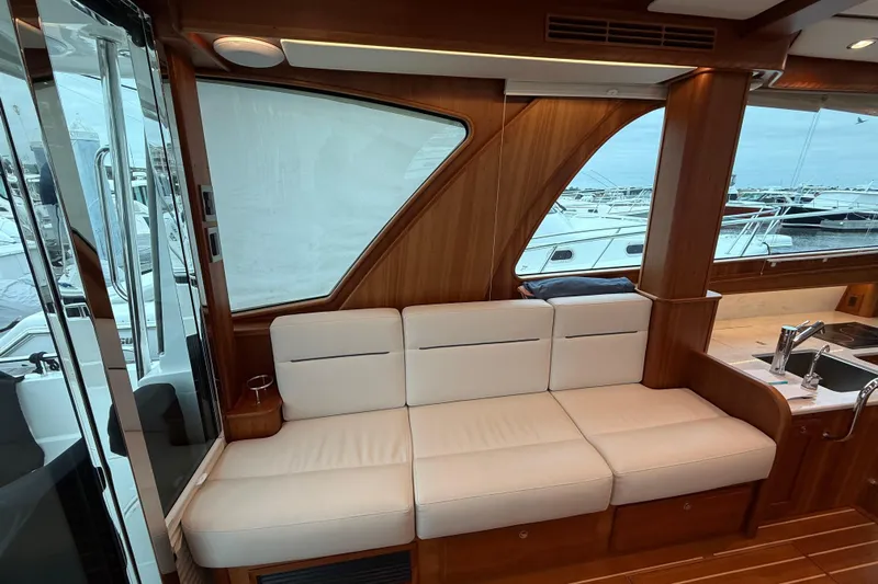 Kay Lee Jean Yacht Photos Pics Luxurious interior of 2023 Sabre 43 Salon Express yacht with white seating and wooden accents.