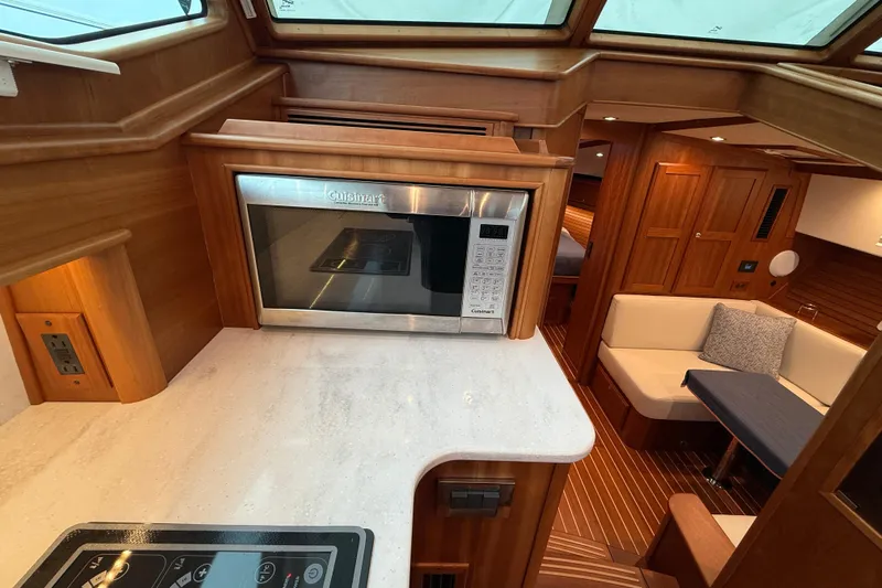Kay Lee Jean Yacht Photos Pics 2023 Sabre 43 Salon Express interior with microwave, seating, and wood finish.