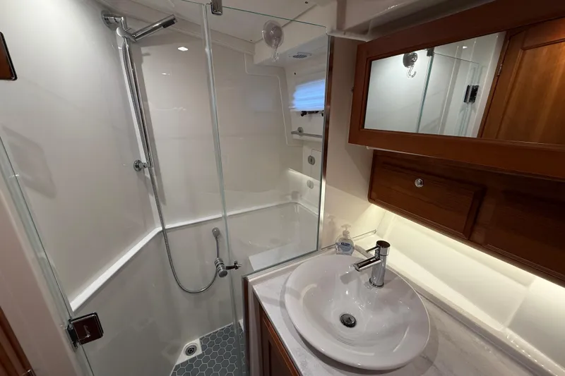 Kay Lee Jean Yacht Photos Pics Modern bathroom in 2023 Sabre 43 Salon Express yacht with glass shower and sleek sink.