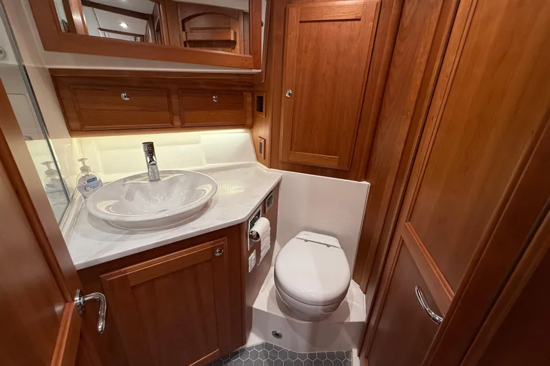 Kay Lee Jean Yacht Photos Pics Luxurious 2023 Sabre 43 Salon Express bathroom with wooden cabinetry and modern fixtures.