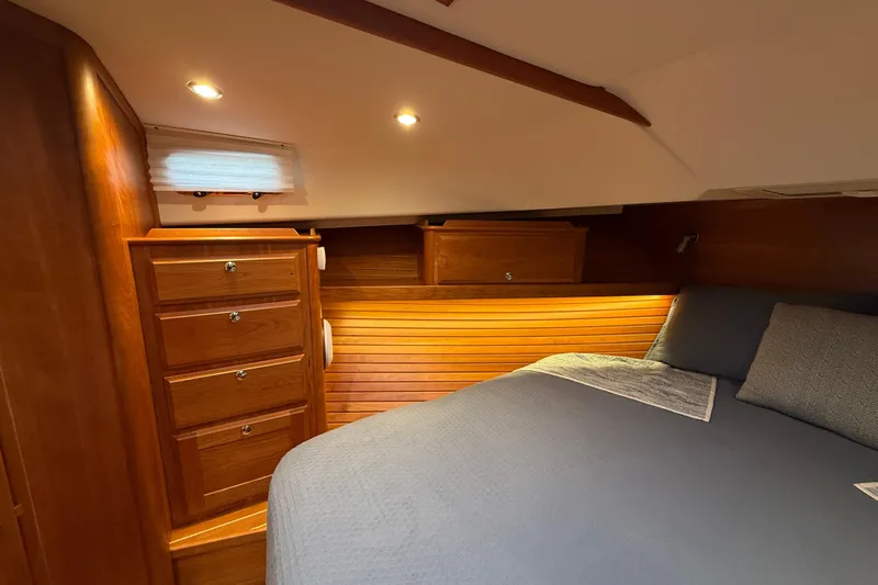Kay Lee Jean Yacht Photos Pics Luxurious 2023 Sabre 43 Salon Express cabin with elegant wood finish and cozy bedding.
