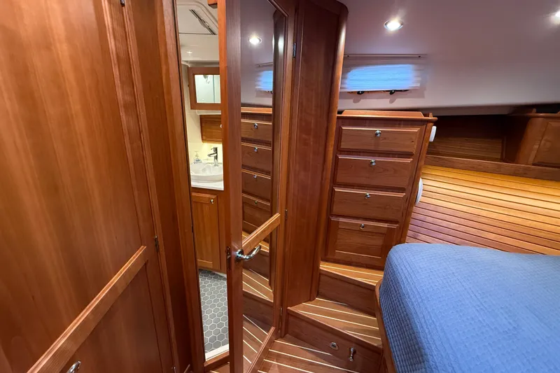 Kay Lee Jean Yacht Photos Pics Luxurious 2023 Sabre 43 Salon Express yacht interior with wooden cabinetry and cozy bedroom.