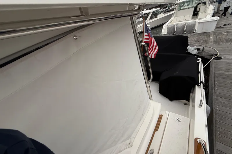 Kay Lee Jean Yacht Photos Pics 2023 Sabre 43 Salon Express yacht docked, featuring American flag and covered seating area.