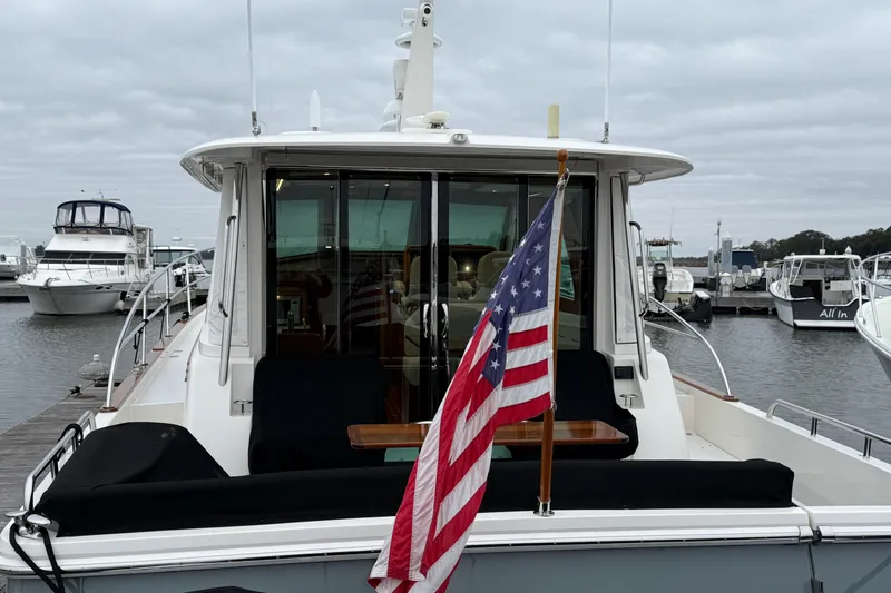 Kay Lee Jean Yacht Photos Pics 2023 Sabre 43 Salon Express yacht docked with American flag, overcast sky.