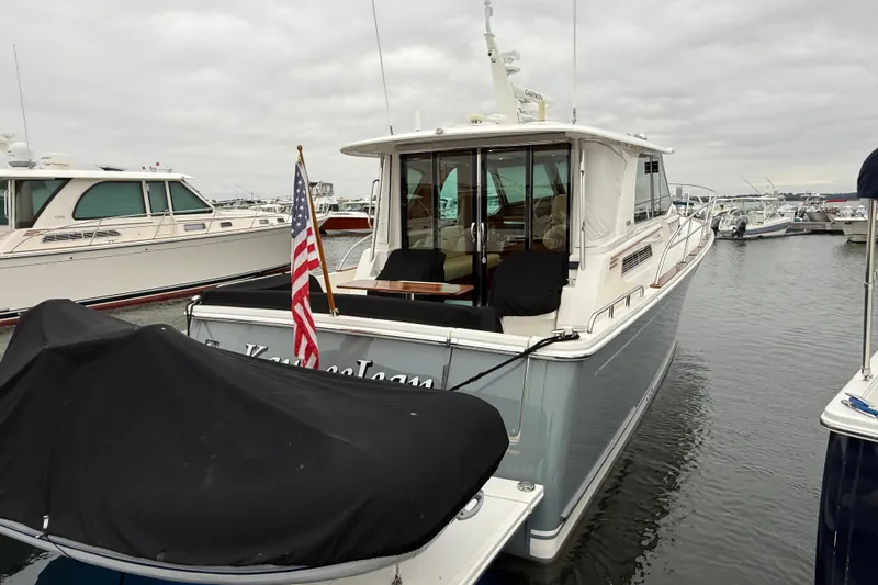 Kay Lee Jean Yacht Photos Pics 2023 Sabre 43 Salon Express yacht docked in a marina, rear view with American flag.