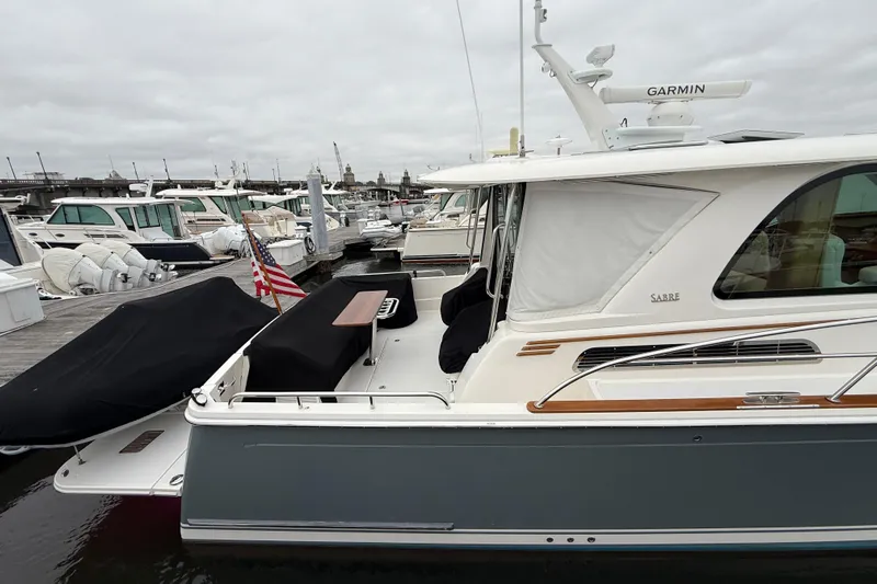 Kay Lee Jean Yacht Photos Pics 2023 Sabre 43 Salon Express yacht docked at marina, featuring sleek design and American flag.